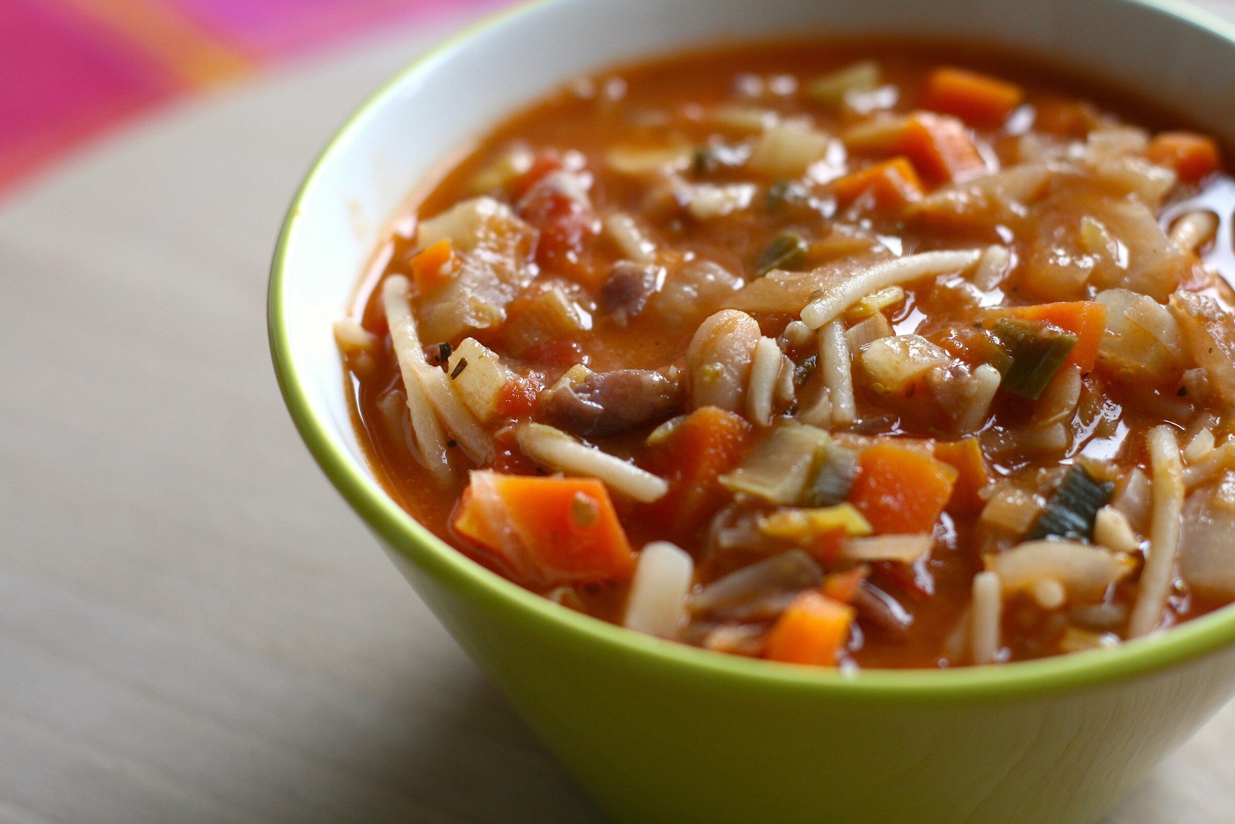 A bowl of minestrone soup with vegetables, beans and pasta