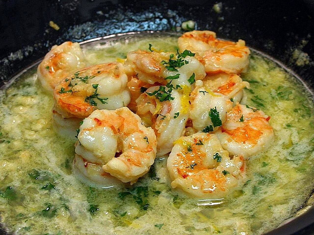 Shrimp scampi in a garlic butter and parsley sauce in a skillet